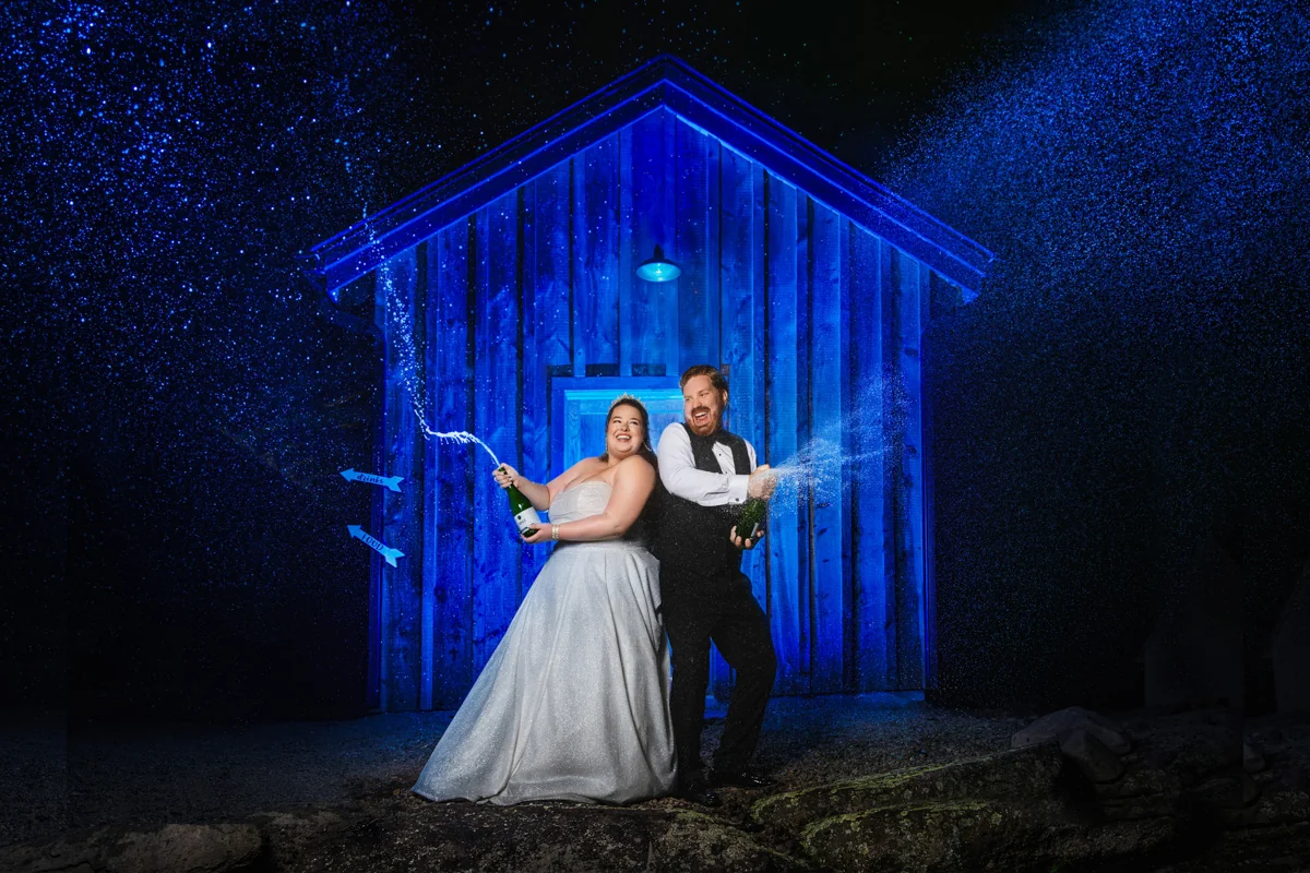 Creative wedding portrait — champagne spray with blue night lighting, George Pompilio Photography